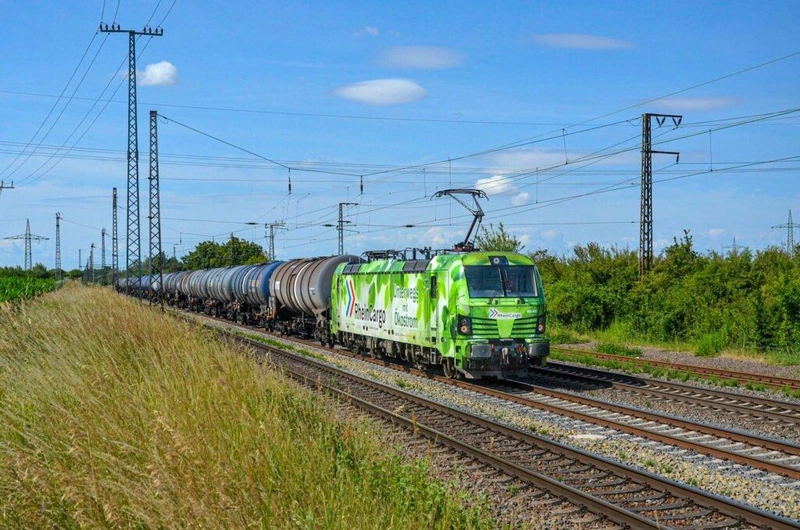 Leveles design a környezetért: a Rhein Cargo 192 033 pályaszámú, egyedi matricát viselő Siemens Smartron villanymozdonya halad Szászország tartományban fekvő, német Großkorbetha állomás előtt a Leunába tartó üres tartályvonatával / Fotó: Lakó Botond