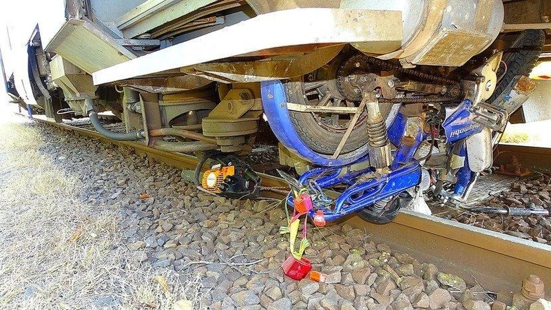 Összetört motoros bicikli a vonat kerekei között (Fotó: Lcafe.hu)